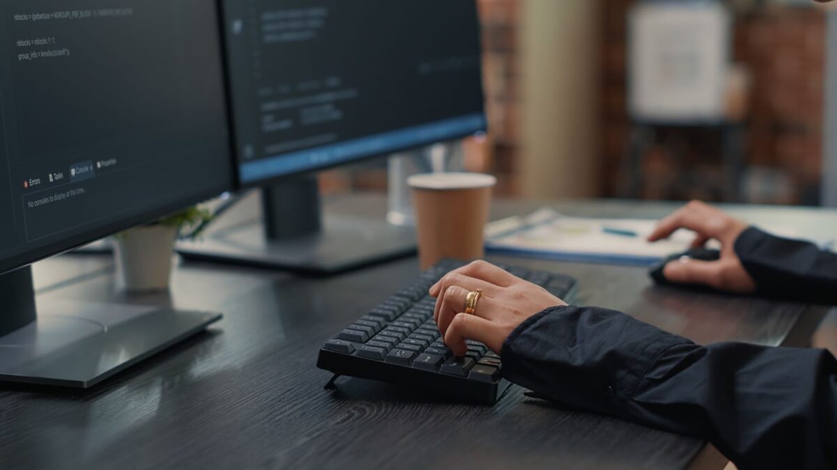 Closeup of hands typing code on keyboard