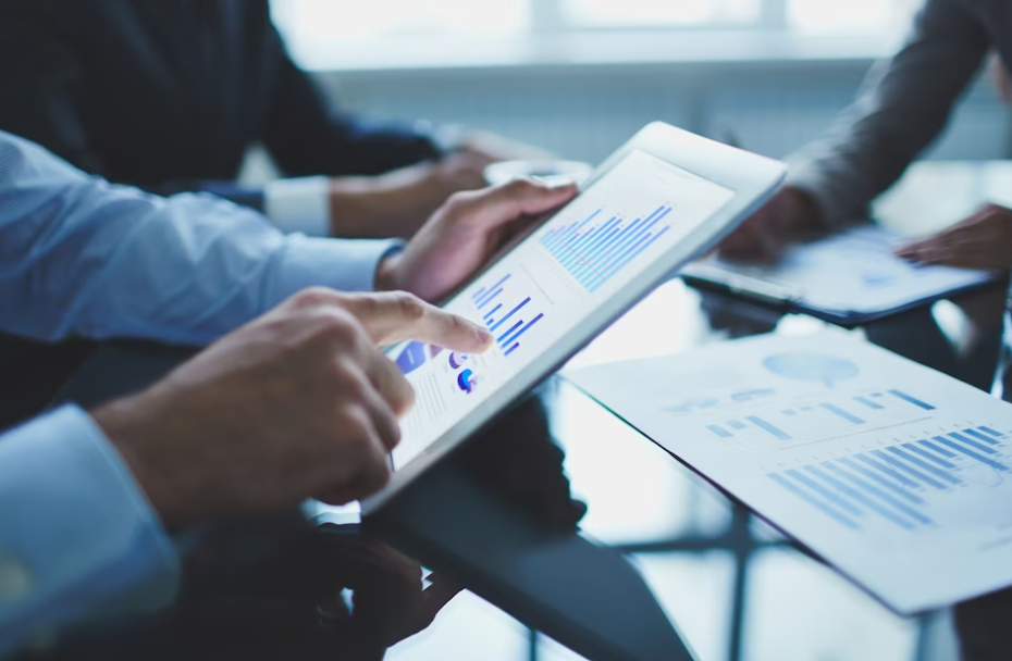 man holds a tablet with diagrams on it in the office near his colleagues